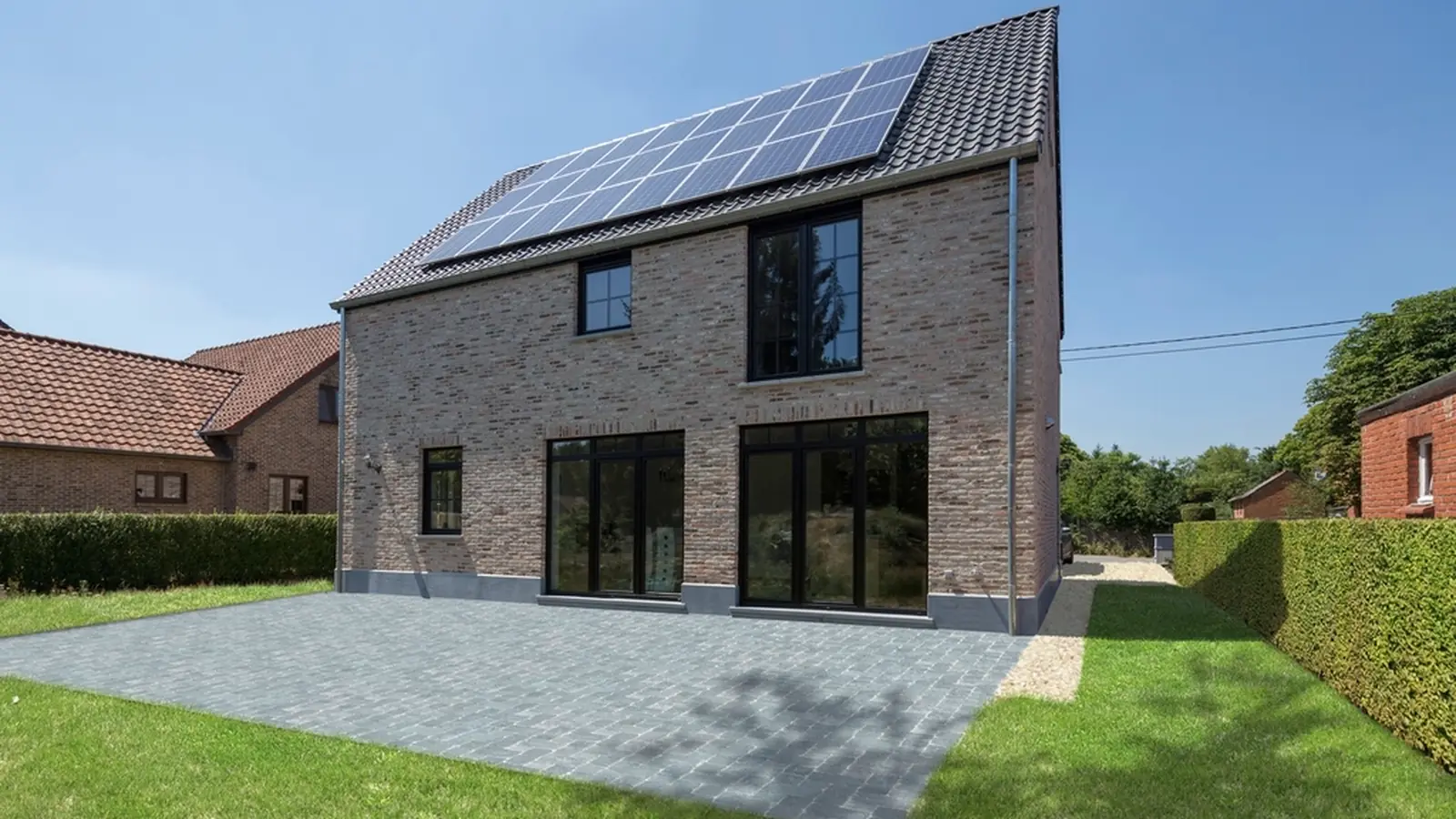 A modern two-storey house with solar panels on the main roof