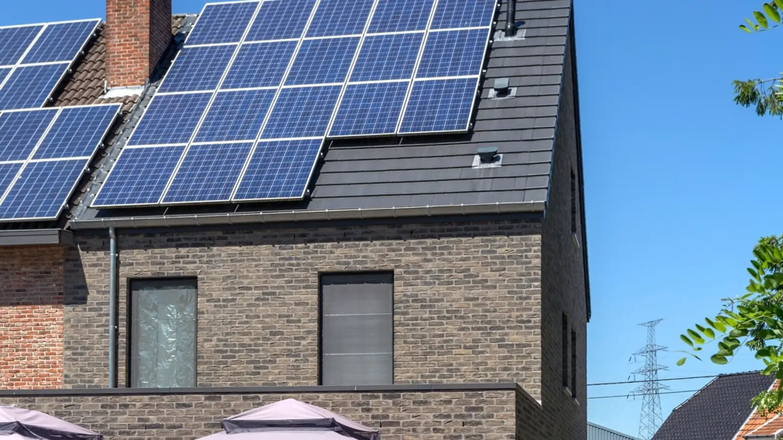 Solar panels on the roof of a two-storey brick house